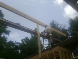 Carpenter setting a ridge beam over a new addition frame — Ice Dam Removal by Roofing Brothers in Litchfield