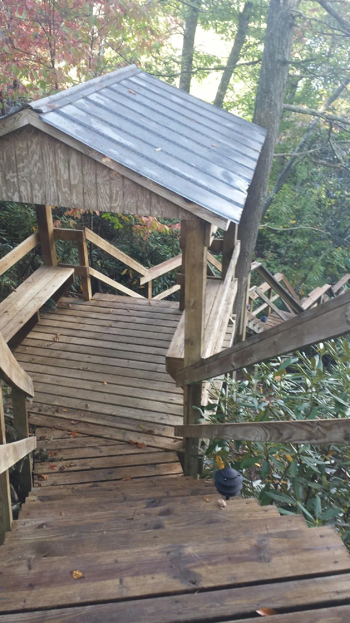 Metal roofed shelter over wooden steps on a wooded walkway — Skylight Repair & Installation work by our crew in Litchfield